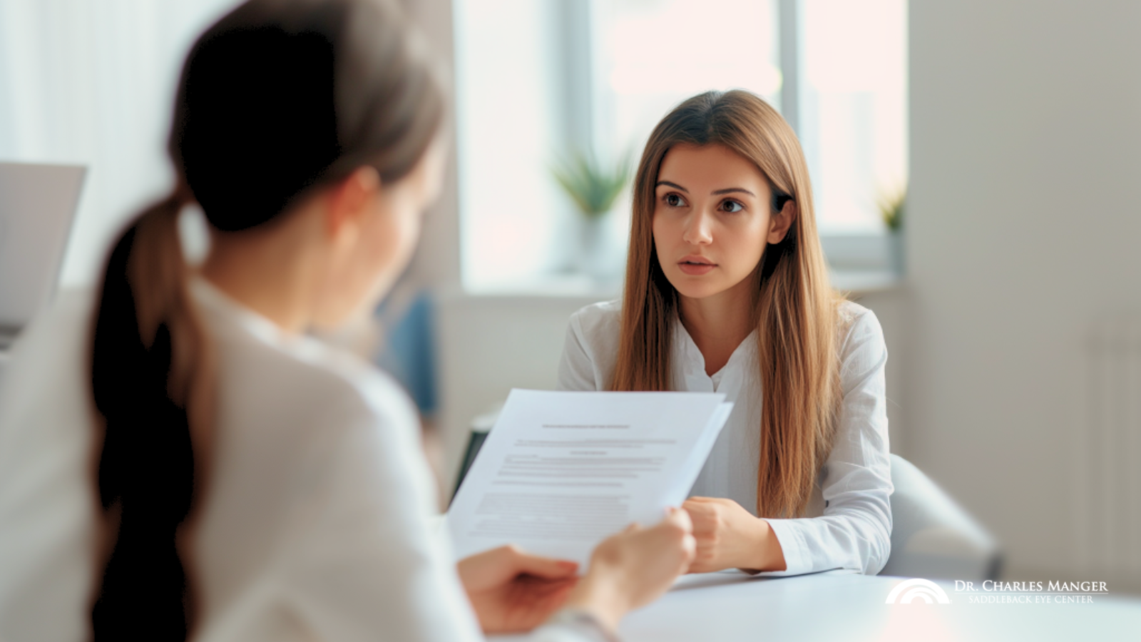 A woman skeptically looking at a clinic clerk explaining the details of their lifetime guarantee on LASIK eye surgery