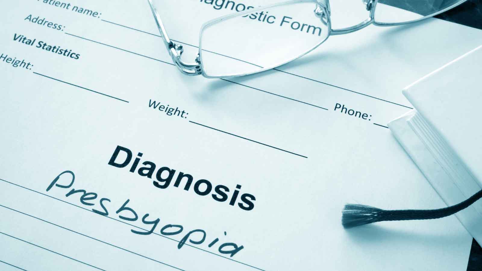 Diagnosis form showing presbyopia written with glasses nearby.