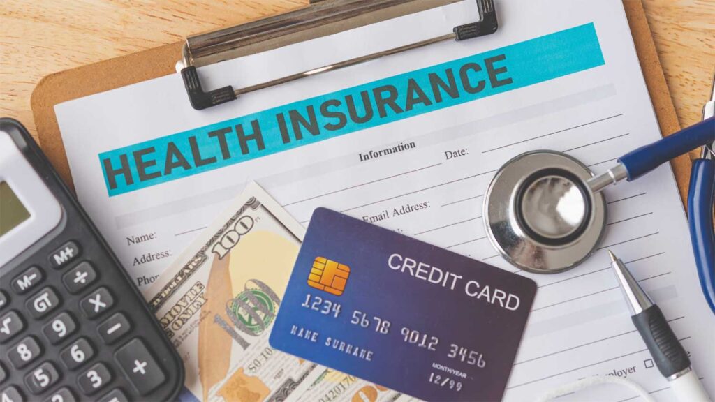 Health insurance form with a credit card, cash, stethoscope, and calculator